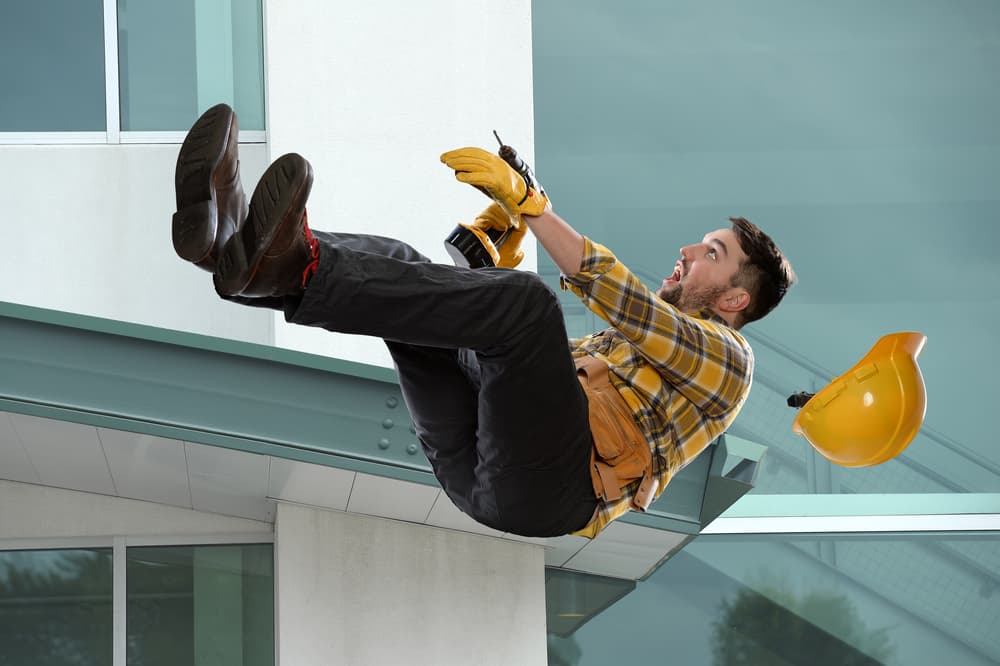 Construction worker slipping from ledge outside a building